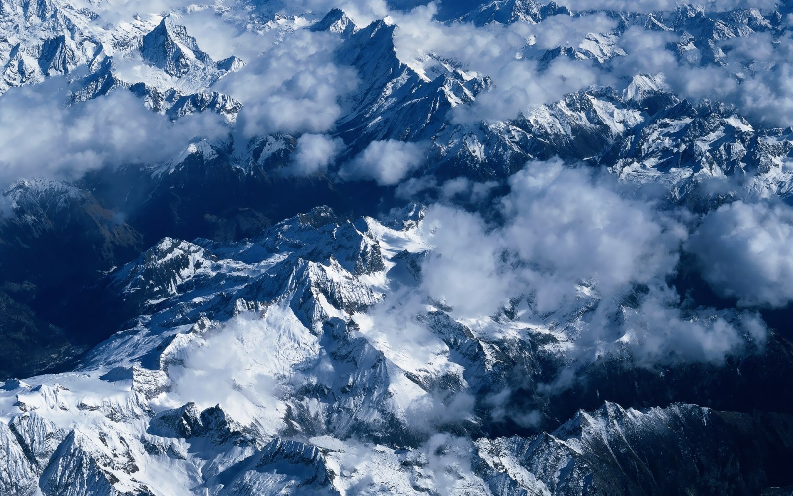 Snowy Mountain Peaks Through Clouds Wallpaper — Nature wallpaper