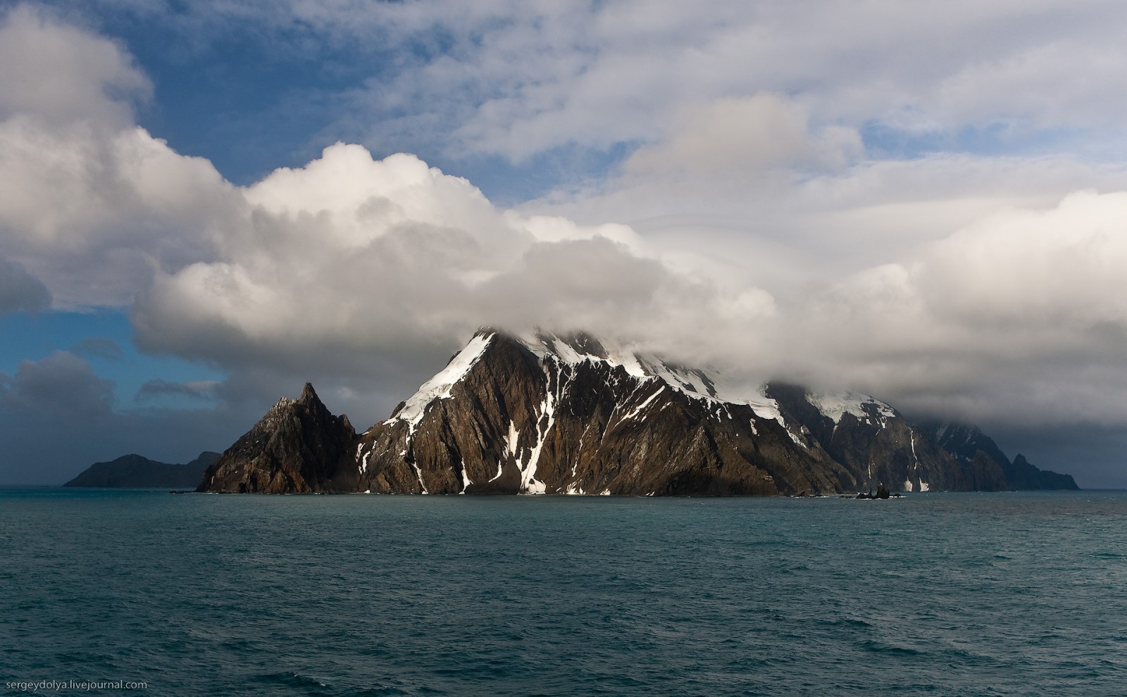 Rocky Island Beneath Heavy Clouds Wallpaper — Nature wallpaper
